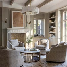 a living room with couches, chairs and a fire place in front of a fireplace