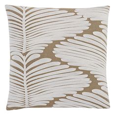 a brown and white pillow with a leaf pattern on the front, sitting on a white background