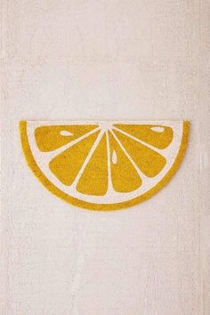 an orange cut in half sitting on top of a white wall next to a towel