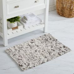 a bathroom with a white vanity and rug on the floor