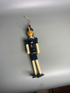 a wooden toy hanging from a hook on a wall in the shape of a man