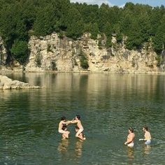 some people are playing in the water near rocks