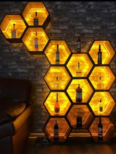 the shelves are filled with bottles and liquors in hexagonal shapes, lit up by yellow lights