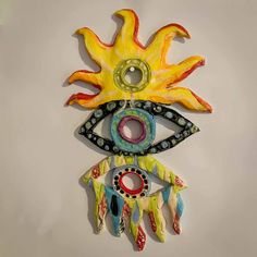 a decorative wall hanging with an eye and sun