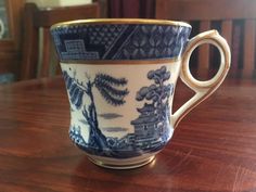 a blue and white cup sitting on top of a wooden table