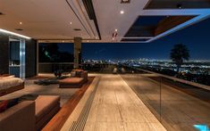 a living room filled with furniture and a large window overlooking the city lights at night