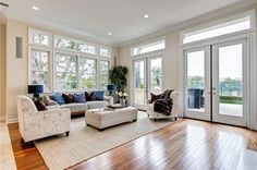 a living room filled with white furniture and lots of windows on top of each other