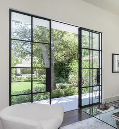 a modern living room with glass doors leading to the patio and trees in the back yard