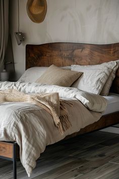 a bed with pillows and blankets on it in a bedroom next to a wall mounted wicker basket