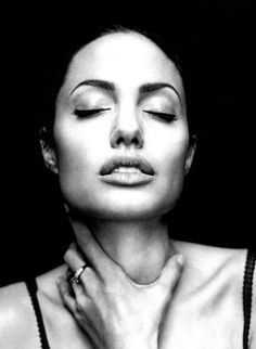 a black and white photo of a woman with her hands on her chest looking up