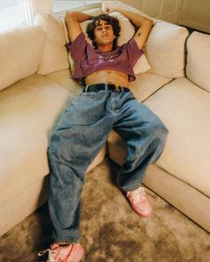 a man laying on top of a white couch