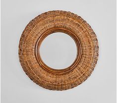 a round wicker mirror hanging on the wall