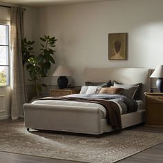 a bedroom with a bed, nightstands and two lamps