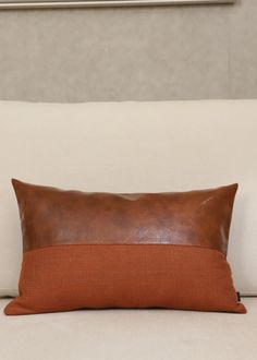 a brown pillow sitting on top of a white couch