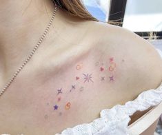 the back of a woman's shoulder with stars and circles on her left side