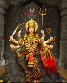 a statue of the hindu god hantuka with two arms outstretched and holding a staff