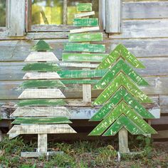 three wooden christmas trees sitting in front of a window