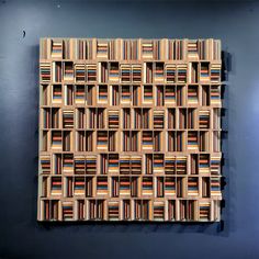 a piece of art made out of wooden blocks on a gray wall with blue walls