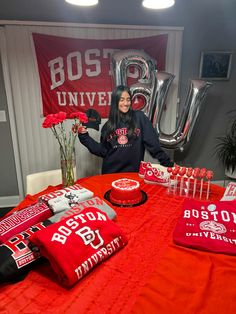 a woman standing in front of a table with red and white decorations