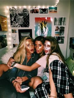 three girls are posing for the camera with their faces painted