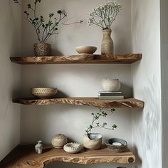 three wooden shelves with vases and flowers on them