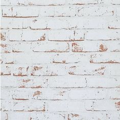 an old white brick wall with rusted paint