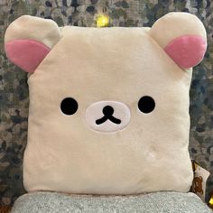 a white teddy bear pillow sitting on top of a chair