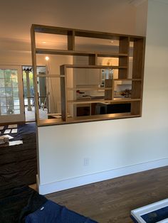 an empty living room and kitchen are seen through the window in this house remodeling project