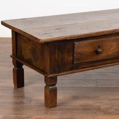 an old wooden table with two drawers on it