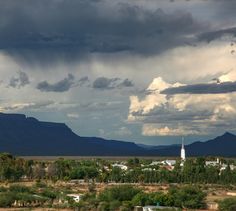 the sky is dark and cloudy with mountains in the background