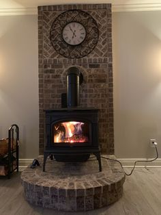 a fireplace with a clock on the wall above it and a fire place next to it