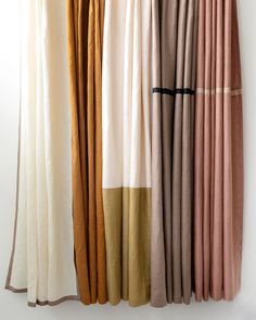 several different colored curtains hanging on a wall