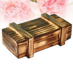 a wooden box sitting on top of a white table next to pink peonies