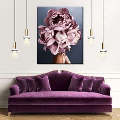 a living room with a purple couch and large flower painting on the wall above it