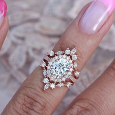 a close up of a person's hand with a diamond ring on their finger