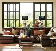 a living room filled with lots of furniture next to large windows and a coffee table