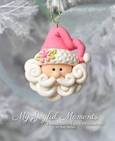 a christmas ornament with a pink hat on it's head hanging from a tree