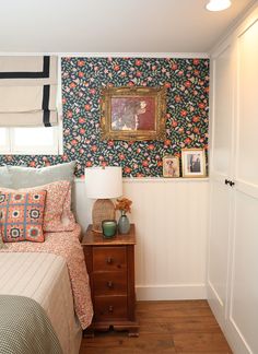 a bed room with a neatly made bed and a painting on the wall