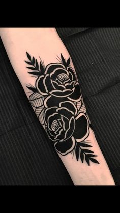 a black and white rose tattoo on the arm