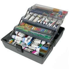 a black box filled with lots of different types of paint and pencils on top of each other