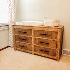 a wooden dresser with two baby cribs sitting on it's top shelf