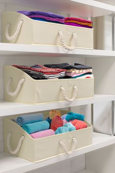 two white storage bins holding towels and blankets