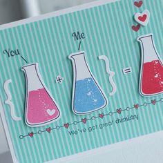 a handmade card with three flasks and hearts on the front, two are red, one is blue