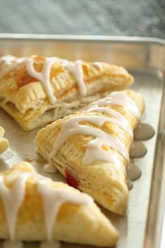 easy cherry turnoverers with white icing on a baking sheet