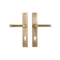 two brass door handles with key holes on each side and an open one in the middle