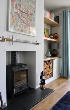 a living room with a fire place and bookshelves on the wall above it