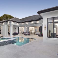 a house with a swimming pool in front of it and an open patio area to the side