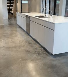 an empty kitchen with white cabinets and stainless steel appliances in the middle of the room