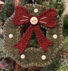 a christmas ornament with a red bow hanging from it's side on a tree