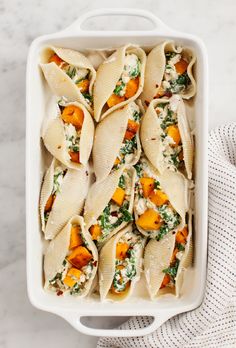 several tortilla shells with spinach and cheese in a casserole dish